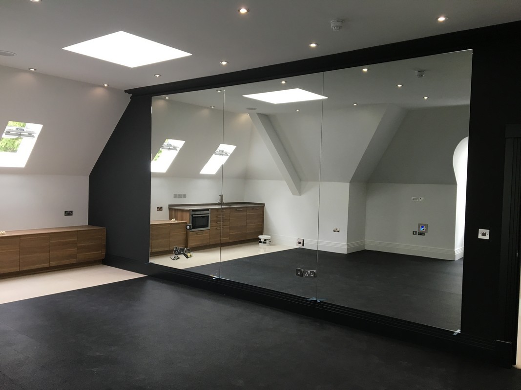 Frameless glass wall dividing loft conversion in Crouch End
